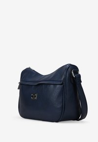 Bolso de hombro de cuero azul marino con textura suave, forma redondeada, cierre con cremallera y un detalle de hardware plateado en el frente.