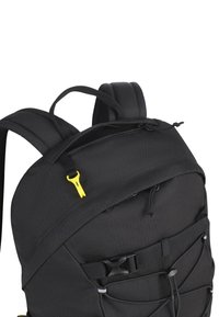 Zwarte rugzak van duurzaam fabricage, gevoerde schouderbanden, externe ritszak, gele hardware-accenten en een bungeekoord detail aan de voorkant.