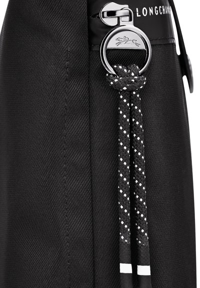 Black fabric bag featuring a smooth texture, silver zipper hardware, woven black and white rope accents, and a logo detail.