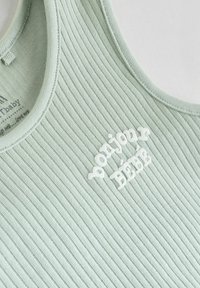 Hellgrünes, geripptes Tanktop mit weißem Text "bonjour bébé." Verfügt über einen runden Ausschnitt und eine weiche Textur. Einfaches Design ohne zusätzliche Muster.