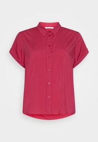 Camisa de manga corta con botones en un vibrante color rosa. Presenta un cuello clásico, una textura suave y un dobladillo curvado. Diseño simple sin patrones.