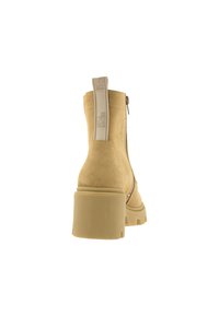 Botín de ante marrón con tacón cuadrado, cremallera lateral y tirador con marca. Textura suave y diseño de suela resistente para mayor durabilidad.