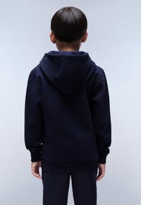 Felpa con cappuccio blu navy in tessuto texturizzato, con polsini e orlo a coste. La vista posteriore mostra una vestibilità morbida con un grande cappuccio.