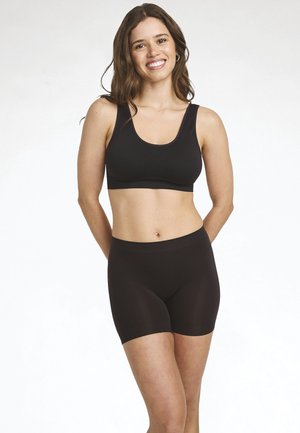 Schwarzer nahtloser Sport-BH mit breiten Trägern und passenden schwarzen high-waisted Shorts. Beide aus glattem, elastischem Stoff.