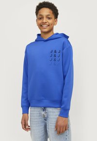 Modrá mikina s kapucí a přední kapsou, na levé straně s potiskem v černé barvě. Materiál vypadá hladce a mikina má nastavitelnou kapuci.