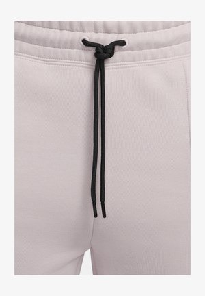 I pantaloni della tuta grigi chiari presentano un tessuto testurizzato, una vita elastica e lacci neri con terminali in metallo.