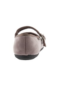Zapatilla de terciopelo marrón con suela de goma flexible, parte trasera acolchada y un diseño cosido. Presenta una correa de tela con una hebilla de metal.
