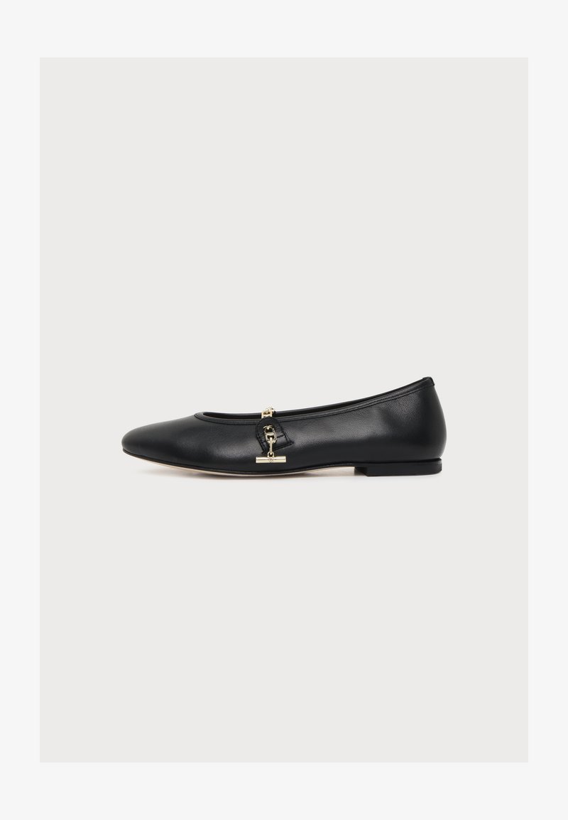 Ballerine plate en cuir noir avec un petit détail de boucle dorée sur le côté, talon bas et bout arrondi, présentée de profil sur fond blanc.