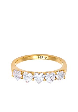 Anello d'oro con cinque pietre trasparenti a forma di cuore disposte in fila, con timbro "925" all'interno della fascia.