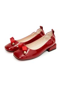 Bailarinas de charol rojo con punta cuadrada, que presentan un lazo decorativo y un pequeño tacón bloque. Textura suave.