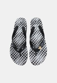 Infradito neri con suola bianca testurizzata caratterizzata da pois neri e motivi a righe. Accentazione con stelle dorate sulle cinghie.