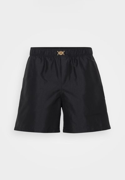 Shorts noirs en tissu lisse, dotés d'une taille élastique avec un détail de boucle en métal doré à l'avant. Design simple et classique.