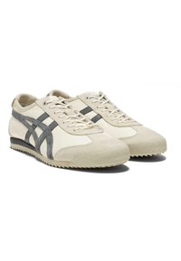 Sneaker beige realizzate in pelle e camoscio, con dettagli grigi, chiusura con lacci e suola in gomma testurizzata con motivo a zigzag.