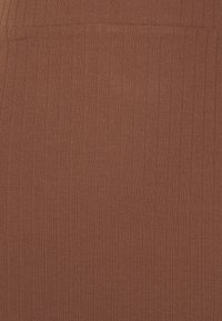 Tissu en tricot côtelé de couleur brun rouge chaud. La texture de la surface est douce avec des lignes verticales créant des motifs subtils. Aucun détail supplémentaire.