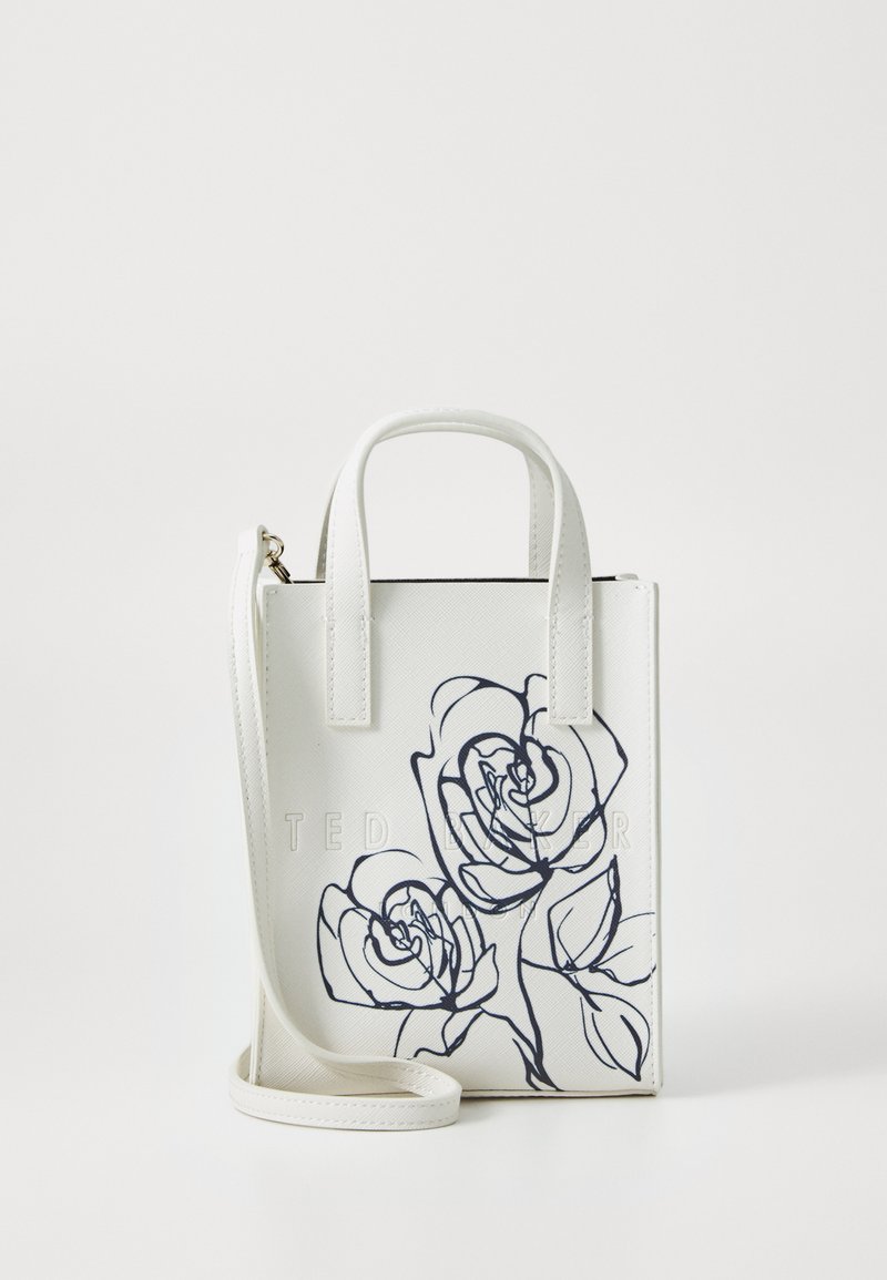 Mini borsa bianca con illustrazioni di rose blu scuro, finitura testurizzata, due manici corti e una tracolla lunga e regolabile. Logo "Ted Baker" embossato.