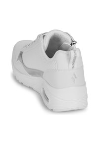 Weißer Sportschuh mit strukturierter Oberfläche, silbernen Akzenten und gepolstertem Kragen. Mit einer Zugschlaufe und einem perforierten Design für Atmungsaktivität ausgestattet.