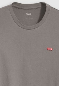 Grijs katoenen T-shirt met ronde hals, voorzien van een klein rood Levi's logo label op de linkerkant van de borst. Zachte textuur met een gladde afwerking.
