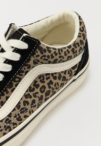 Leopard-print sneakers with canvas upper, black suede accents, white leather side stripe, and rubber sole. Laced design; stitched details.