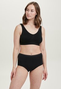 Schwarzes BH- und hochgeschnittenes Unterwäsche-Set aus weichem Stretchmaterial, mit nahtlosem Design und subtiler Textur.