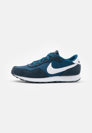 Blå og mørkeblå Nike sneaker med hvid swoosh, snørebånd og sål vist fra siden på hvid baggrund.