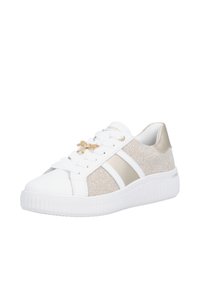 Baskets blanches avec côtés en tissu beige, breloque libellule dorée sur les lacets et semelle épaisse blanche sur fond blanc uni.