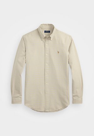 Chemise à manches longues à carreaux beiges et bruns, avec un col classique et un petit logo, fabriquée en tissu tissé.