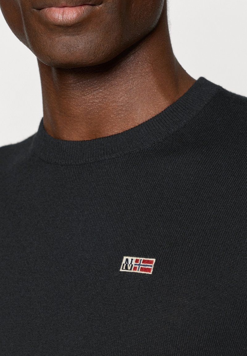 Maglione nero lavorato a maglia con scollo rotondo e un piccolo logo ricamato con un design di bandiera rossa e bianca sul lato sinistro del petto.