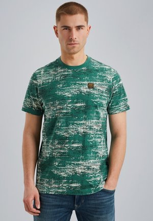 T-shirt vert à motifs avec des manches courtes, doté d'un col rond et de légers éclats blancs et noirs. Comprend une petite étiquette de logo.