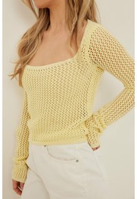 Pull jaune clair, tricoté serré, avec un col carré et des manches longues, doté d'un ourlet côtelé et d'un design à armure ouverte.