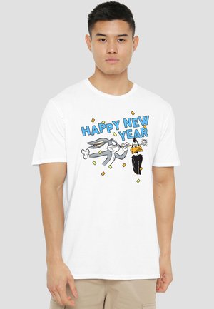 Man wearing a white t-shirt with Bugs Bunny and Daffy Duck and text saying Happy New Year with confetti.