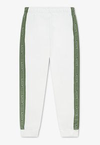 Λευκή φόρμα με κάθετες πράσινες ρίγες στα πλάγια που φέρουν το λογότυπο "LACOSTE". Διαθέτει ελαστική μέση και ριμπ τελείωμα. Μαλακή υφή υφάσματος.