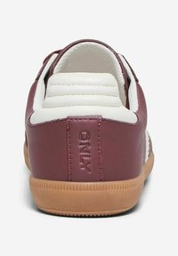 Burgundy leather sneaker with white accents, a padded collar, and a gum sole. Features embossed brand detail on the heel.
