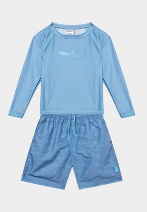 Világoskék hosszú ujjú úszóing kis cápalogóval és hozzáillő, cápás mintás úszónadrág húzózsinóros derékrésszel.