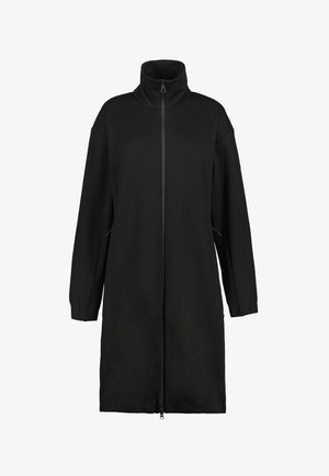 Abrigo largo negro con cuello alto y cremallera frontal completa, con mangas largas y dos bolsillos laterales.