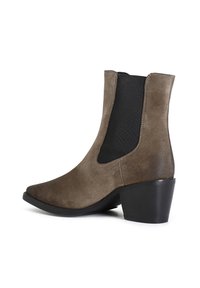 Stivale alla caviglia in suede marrone scuro con pannelli laterali elasticizzati, punta affusolata e tacco corto e spesso. Presenta dettagli di cucitura a contrasto.