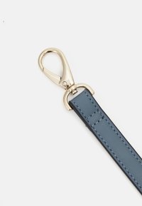 Μπλε δερμάτινο λουρί με χρυσό μεταλλικό κούμπωμα. Το λουρί διαθέτει λεπτομέρειες ραφής και ομαλή υφή, σχεδιασμένο για αντοχή και στυλ.