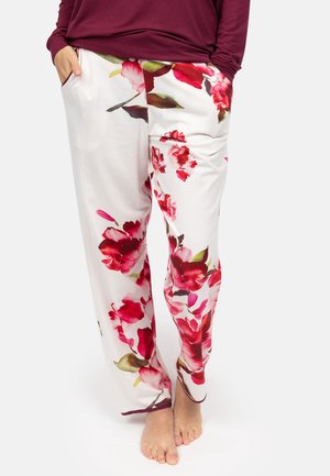 Pantaloni lounge floreali bianchi con audaci motivi di fiori rossi e verdi. Presentano una vestibilità comoda con tasche laterali e una vita elastica.