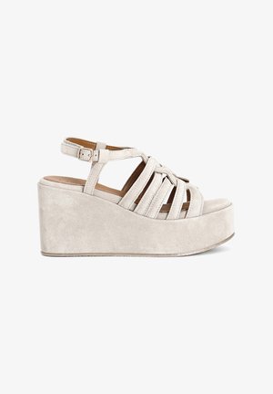 Beige platform sandals with a suede texture, featuring crisscross straps and an ankle buckle. Wedge heel provides added height.