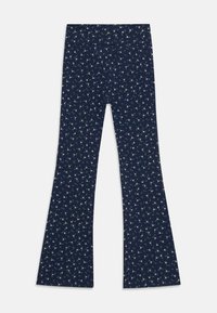 Leggings évasés navy en tissu extensible, présentant un petit motif floral blanc et vert sur l'ensemble. Taille élastique pour plus de confort.