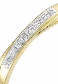 Prsten od žutog zlata s usadkom od srebra koji ima strukturiranu površinu i tri mala, okrugla blistava kamena postavljena u liniji.