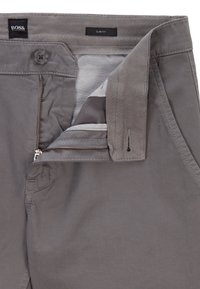 Slim fit grå byxor med en slät tygstruktur, utrustade med dragkedja, knappstängning och insydd etikett på insidan av midjebandet.