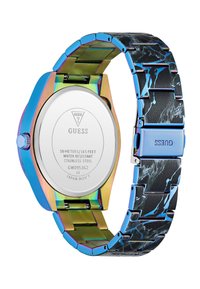 Reloj de pulsera Guess con caja de metal iridiscente, correa de metal con patrón de mármol negro y fondo de acero inoxidable que muestra la marca y los detalles de resistencia al agua.