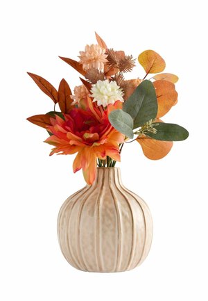 Beige ribt vase, der holder en efterårsbuket med orange, hvide og brune blomster med grønne og brune blade på en hvid baggrund.