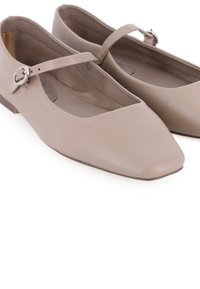 Bailarinas de piel beige con punta afilada, tira en el tobillo y pequeño broche metálico, que cuentan con un tacón plano y un suave forro interior.