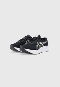 Scarpe sportive nere con texture in maglia, dotate di suole bianche e accenti dorati lucidi sui lati. Chiusura con lacci e design leggero.