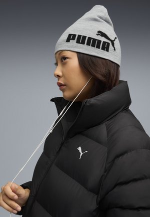 Gray knit beanie with black "PUMA" logo, paired with a black puffer jacket featuring a prominent white Puma logo on the chest.