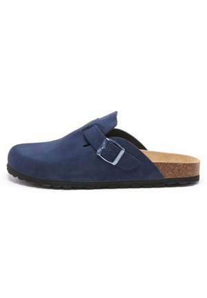 Sabots en daim bleu marine avec un bout arrondi, détail de boucle sur le côté, semelle intermédiaire en liège et semelle extérieure en caoutchouc noir texturé pour une meilleure adhérence.