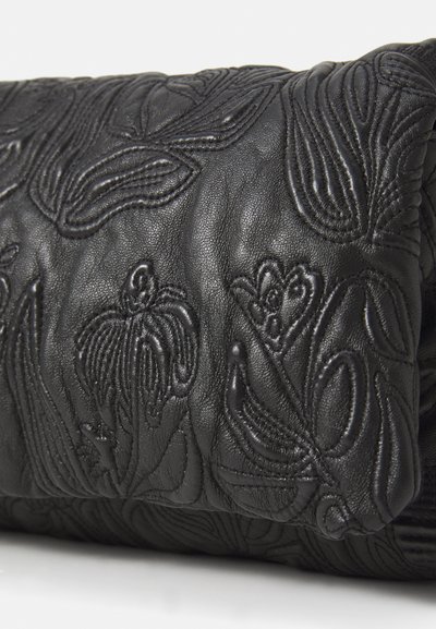 Black leather bag with embossed floral pattern, featuring a smooth texture and soft, rounded shape, highlighting detailed stitching and design.
