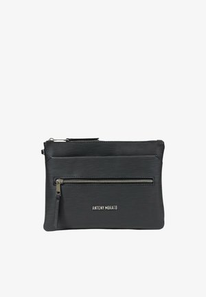 Bolsita negra texturizada con dos compartimentos con cremallera. Presenta un acabado suave y un acento de logo en la parte inferior. Forma compacta y rectangular.