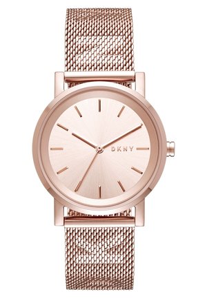 Montre-bracelet DKNY en or rose avec bracelet en maille, cadran minimaliste sans chiffres, trois aiguilles et un design épuré.